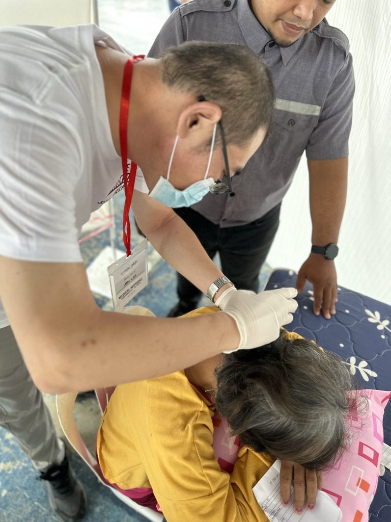 Aimin TCM physician performing acupuncture treatment for pain relief